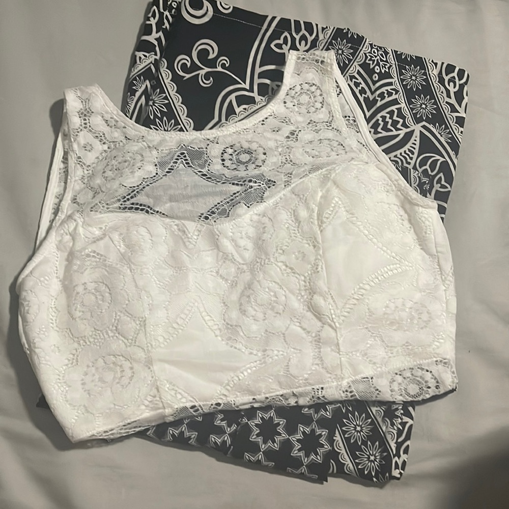 A white and black jumpsuit with flower details and cut out in the back.